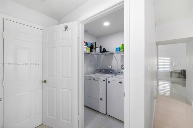 clothes washing area featuring a textured ceiling, laundry area, and separate washer and dryer