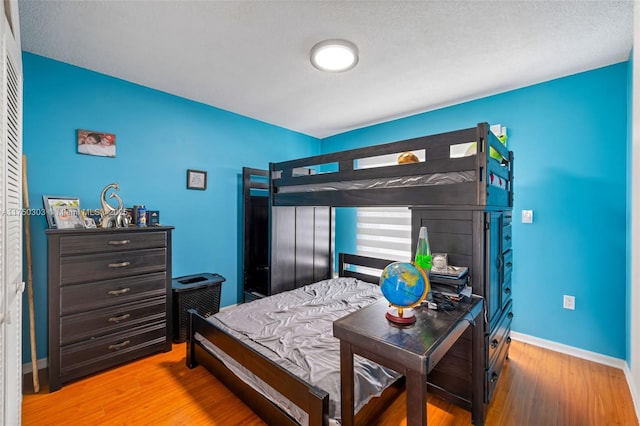 bedroom with baseboards and wood finished floors