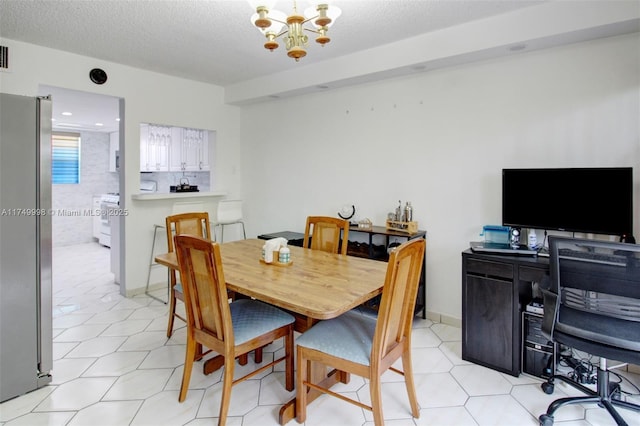 dining area featuring baseboards, visible vents, an inviting chandelier, a textured ceiling, and light tile patterned flooring