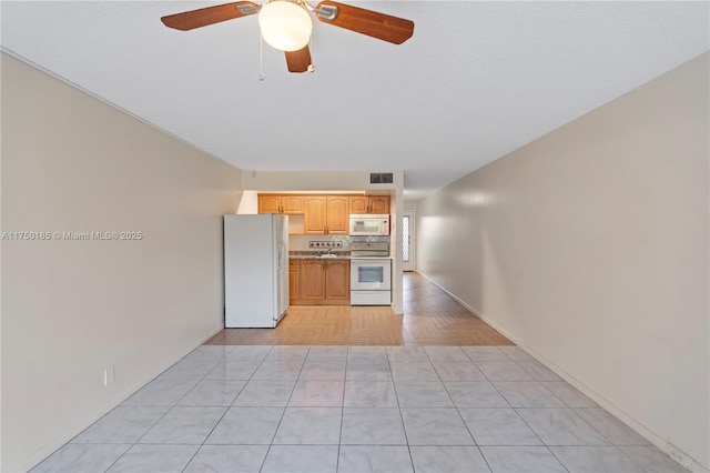 kitchen with ceiling fan, light brown cabinets, white appliances, visible vents, and light countertops