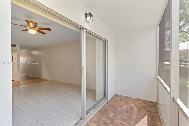 unfurnished sunroom featuring visible vents and a ceiling fan