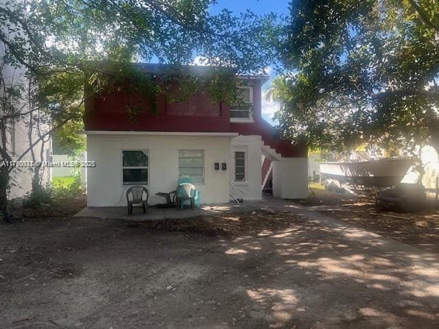 back of property featuring a patio area and stucco siding