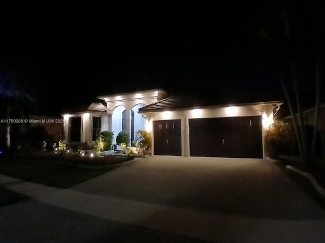 view of front of property featuring a garage, driveway, and stucco siding