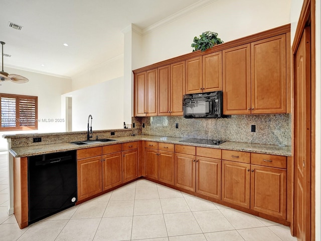 kitchen featuring black appliances, a peninsula, a sink, and brown cabinets