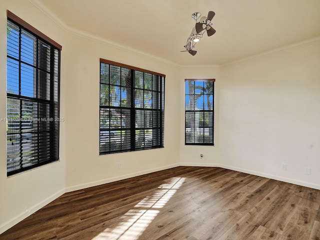 unfurnished room with a ceiling fan, crown molding, baseboards, and wood finished floors