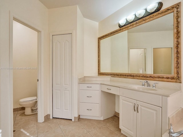 bathroom with toilet, a closet, tile patterned flooring, and vanity