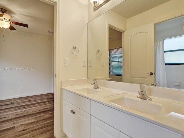 full bath featuring plenty of natural light, a sink, and crown molding