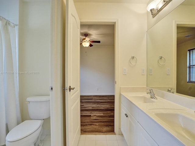 bathroom featuring toilet, tile patterned flooring, ceiling fan, and a sink