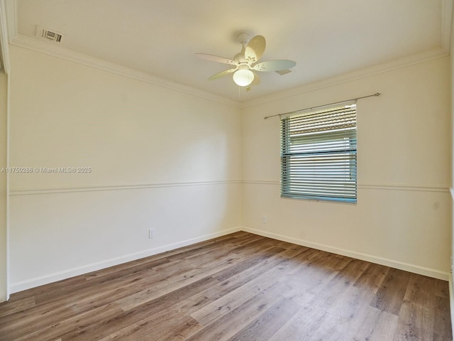 empty room with visible vents, wood finished floors, a ceiling fan, and crown molding