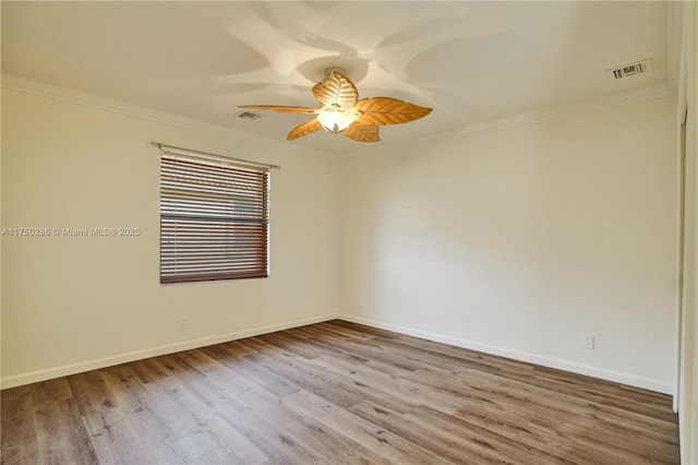 unfurnished room featuring ornamental molding, wood finished floors, and visible vents