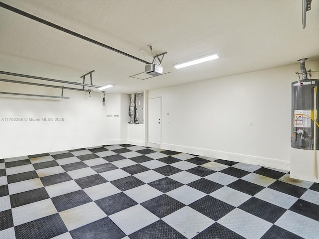 garage featuring baseboards, gas water heater, and a garage door opener