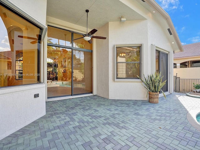 view of patio / terrace with fence and a ceiling fan