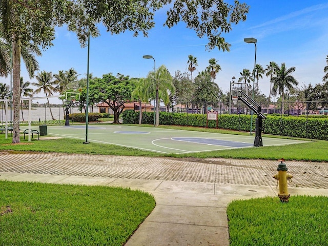 view of basketball court featuring community basketball court, fence, and a lawn