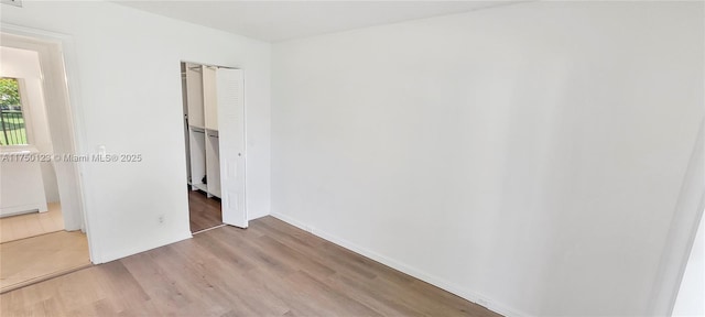 spare room featuring light wood-style flooring and baseboards