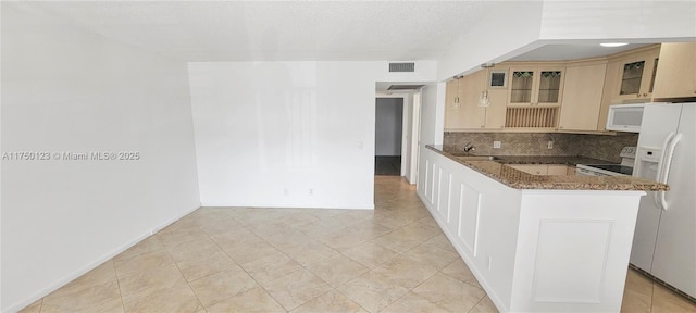 kitchen with white appliances, tasteful backsplash, visible vents, dark stone counters, and glass insert cabinets