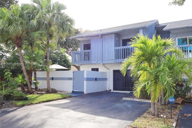 view of front of house with aphalt driveway, a fenced front yard, stucco siding, an attached garage, and a gate