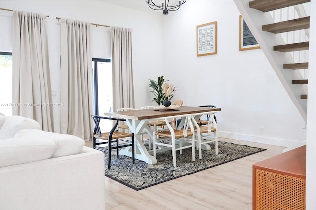 dining space featuring baseboards, stairway, and wood finished floors