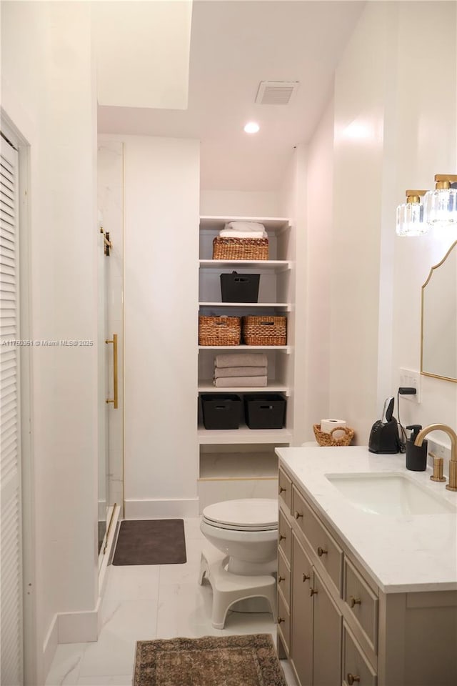 bathroom featuring toilet, vanity, a shower stall, a closet, and recessed lighting