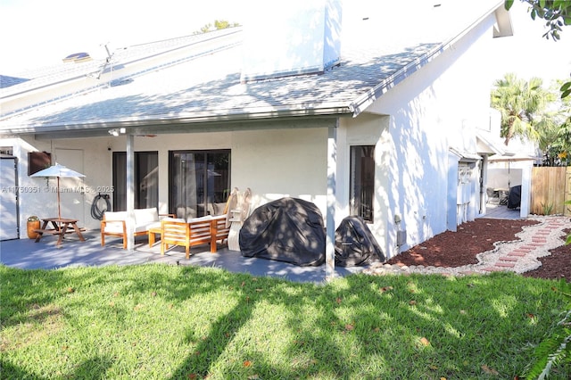 back of house featuring a yard, a shingled roof, outdoor lounge area, and stucco siding