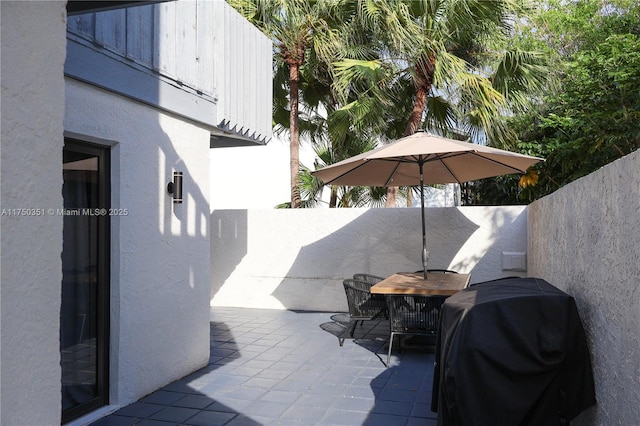 view of patio featuring outdoor dining area, a fenced backyard, and area for grilling