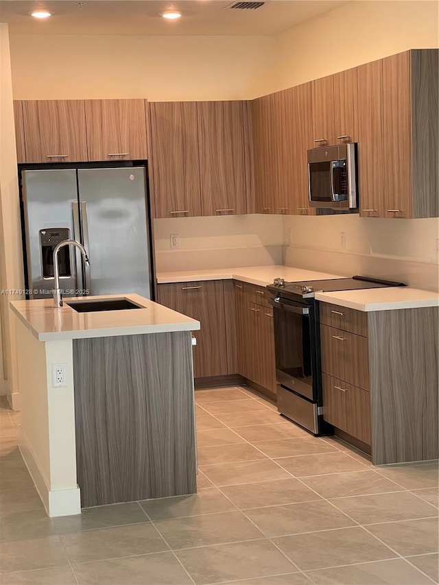 kitchen featuring stainless steel appliances, brown cabinets, light countertops, and modern cabinets