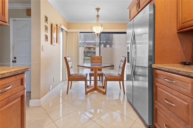 dining space with ornamental molding, baseboards, and light tile patterned floors