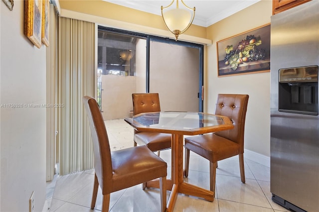 dining room featuring light tile patterned floors, baseboards, and crown molding