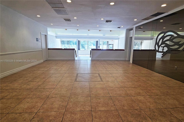 empty room featuring light tile patterned flooring, plenty of natural light, visible vents, and recessed lighting