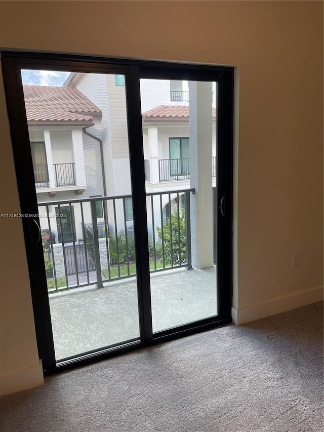 doorway featuring carpet floors, a wealth of natural light, and baseboards