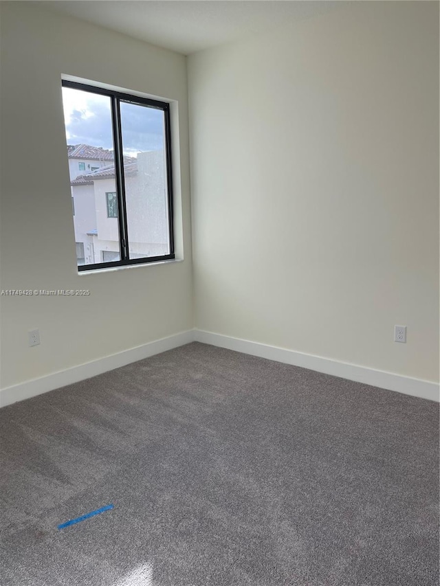 carpeted empty room with baseboards