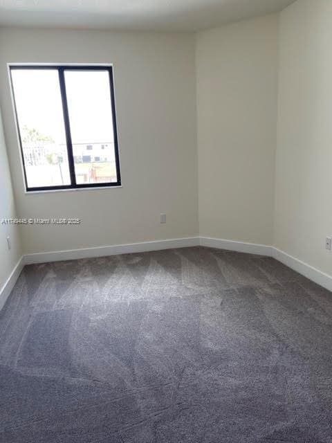 spare room featuring baseboards and carpet flooring