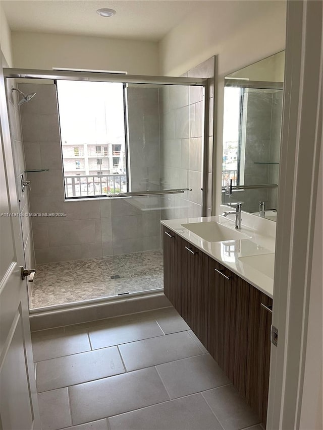 bathroom with a shower stall, tile patterned flooring, and vanity