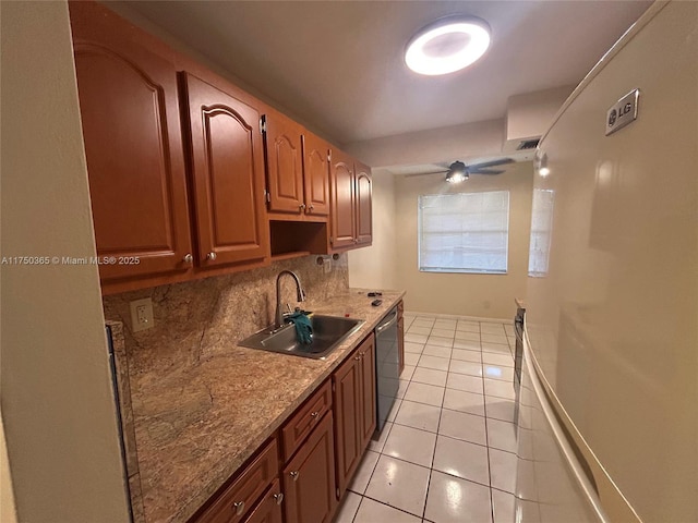 kitchen featuring light tile patterned floors, tasteful backsplash, brown cabinetry, a sink, and stainless steel dishwasher