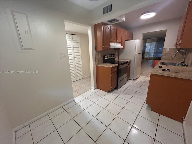 kitchen with visible vents, electric stove, freestanding refrigerator, light countertops, and a sink