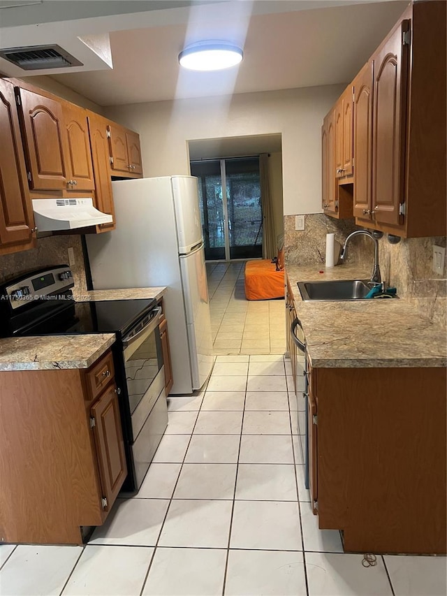 kitchen featuring electric range, tasteful backsplash, visible vents, under cabinet range hood, and a sink