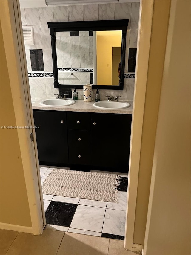 full bathroom featuring a sink, backsplash, and double vanity