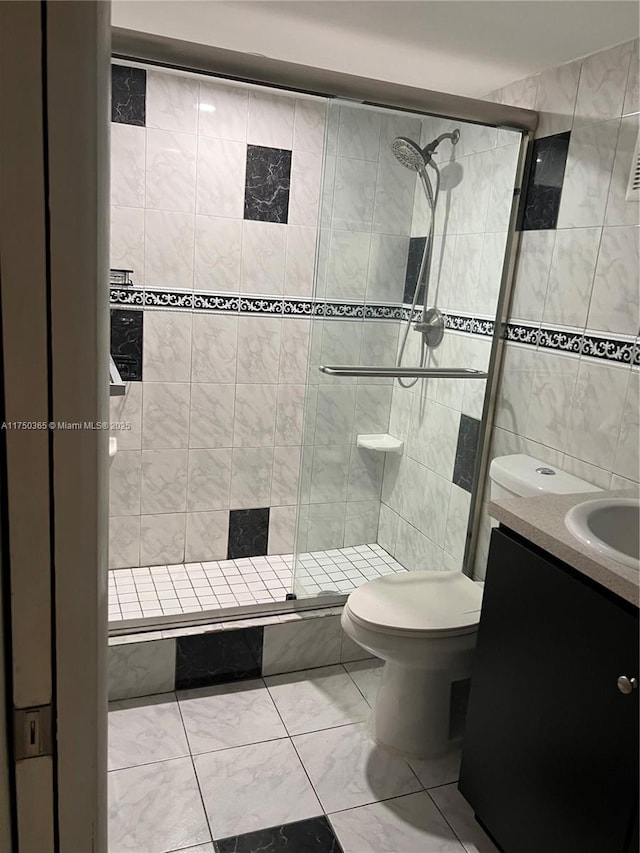 bathroom with toilet, a stall shower, and vanity