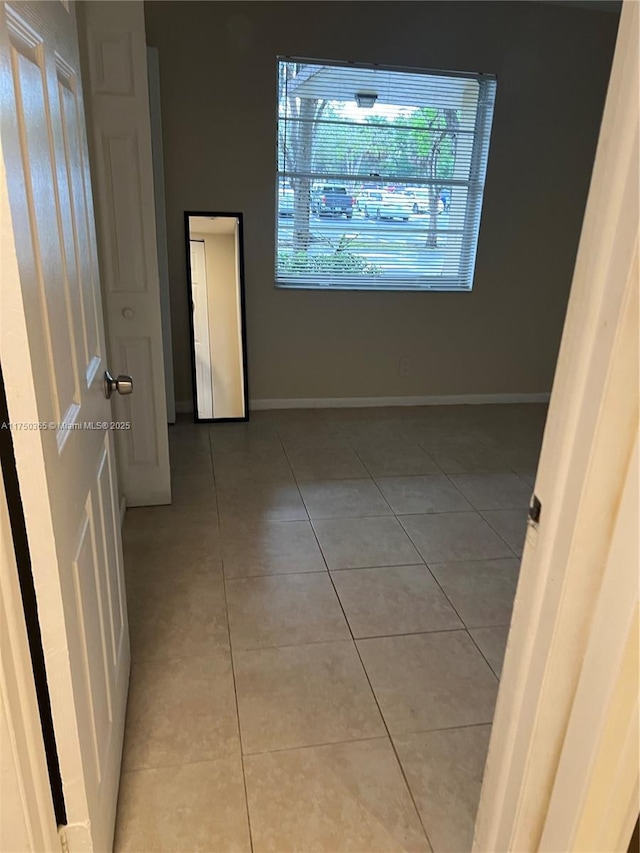 interior space featuring light tile patterned floors and baseboards