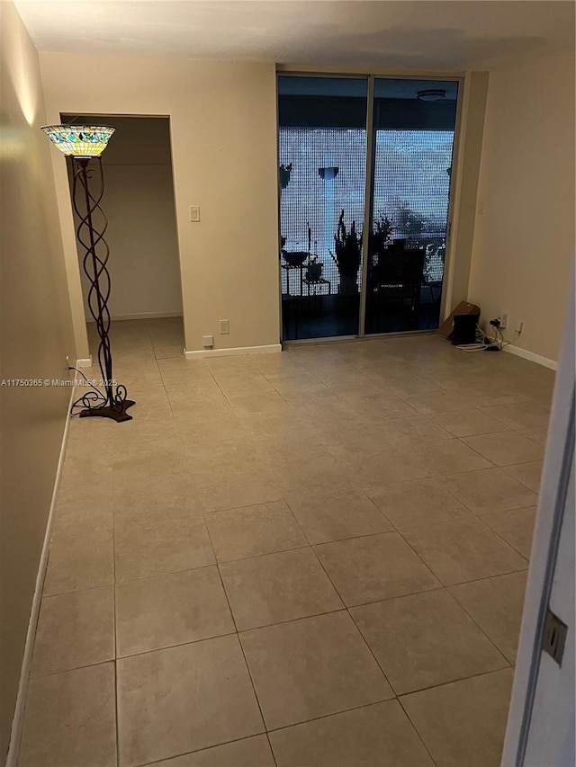 unfurnished room with light tile patterned floors and baseboards