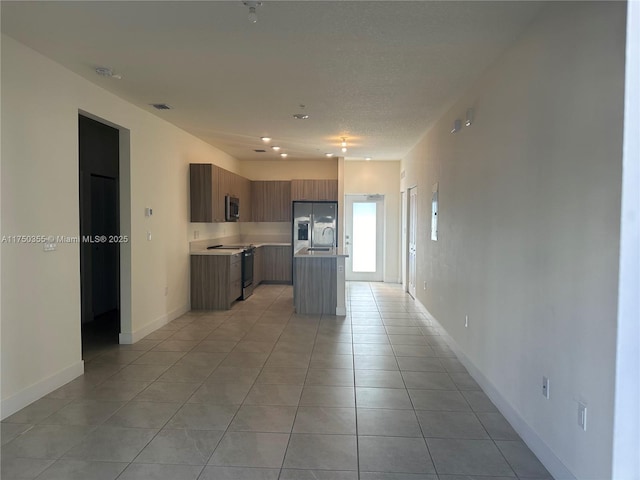 kitchen featuring visible vents, modern cabinets, a kitchen island, appliances with stainless steel finishes, and light countertops