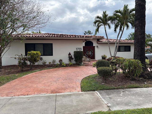 mediterranean / spanish-style home with a tile roof and stucco siding