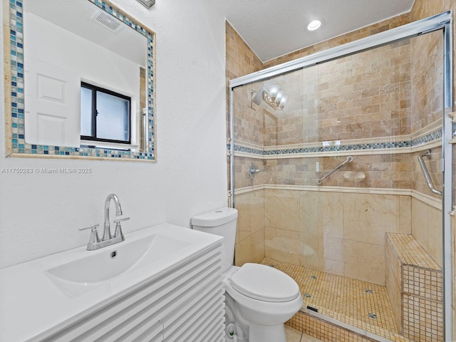 bathroom with a stall shower, visible vents, vanity, and toilet