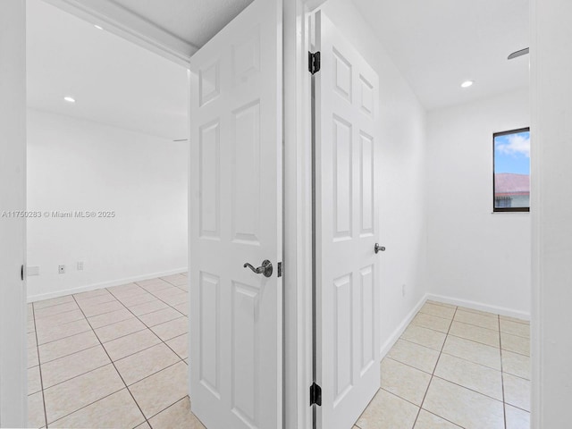 hallway with recessed lighting, light tile patterned flooring, and baseboards