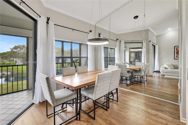 dining area featuring light wood finished floors and ornamental molding