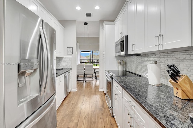 kitchen featuring white cabinetry, visible vents, appliances with stainless steel finishes, and dark stone countertops