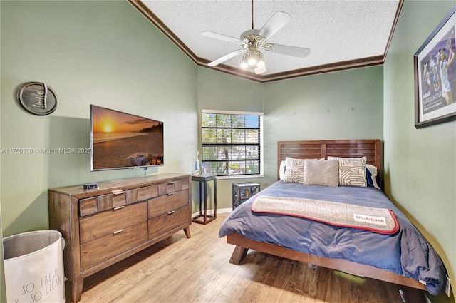 bedroom with a textured ceiling, light wood-type flooring, a ceiling fan, and crown molding