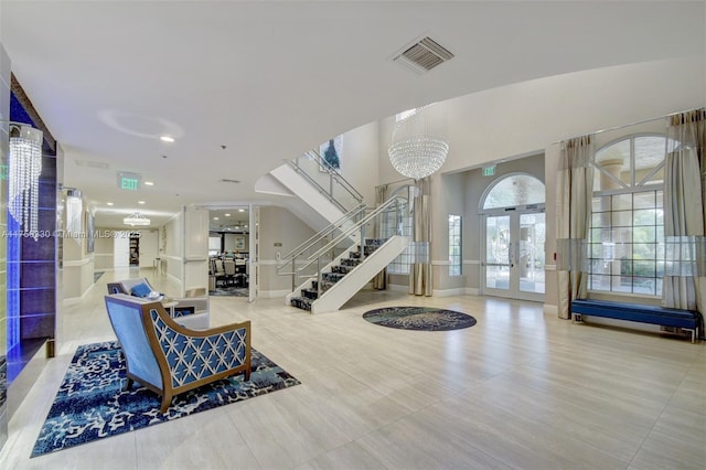 entrance foyer featuring a chandelier, french doors, visible vents, and stairs