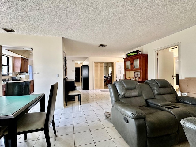 living area with a textured ceiling and visible vents