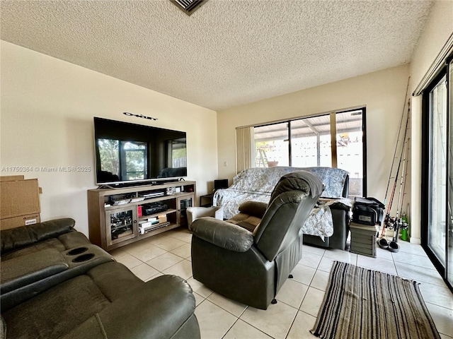 living room with light tile patterned floors, a textured ceiling, and visible vents
