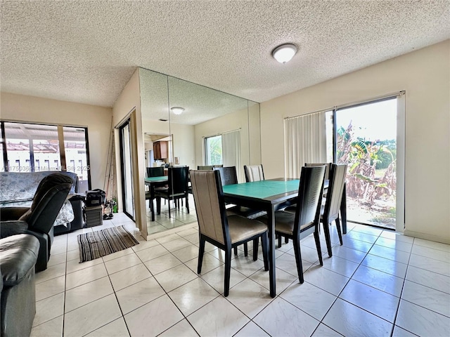 dining space featuring light tile patterned floors and a textured ceiling